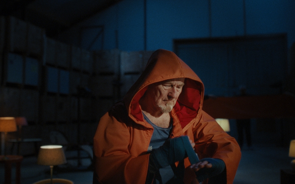 KRIICH Een filmstill uit KRIICH: een Friese man kijkt peinzend in de verte over een weids landschap met zacht licht en een melancholische sfeer.