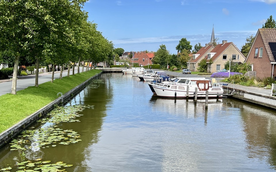 Wetterfreonen haven jachthaven water boten hallum boten in de haven van hallum water met steigers en ligplaatsen met huizen en het dorp op de achtergrond en een bomenrij