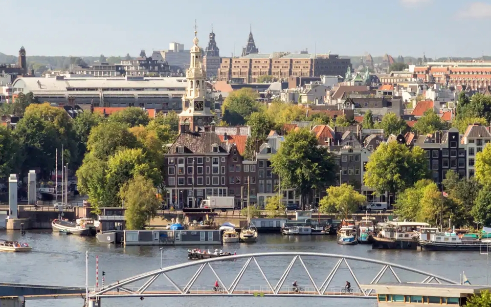 Straatbeeld in Amsterdam met moderne nieuwbouwwoningen en appartementencomplexen.