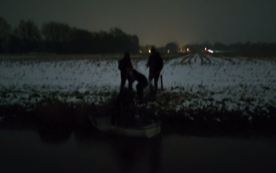 Deelnemers aan de Greppeltocht 2026 steken met een klein bootje een sloot over in het Friese landschap.