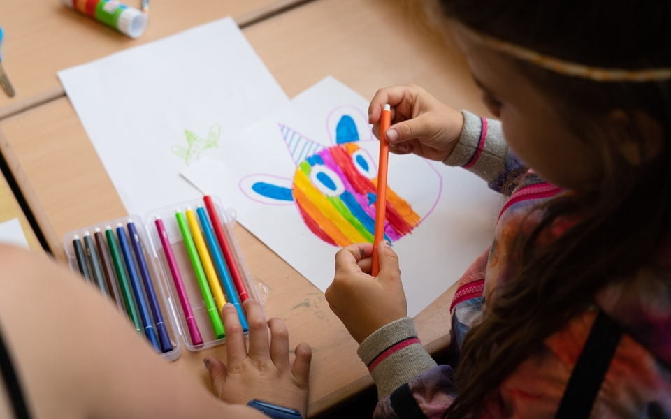 Kind is creatief bezig met tekenen tijdens de knutselclub in de bibliotheek