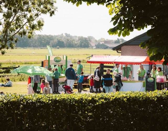 Bezoekers genieten van activiteiten en lekkernijen op het erf tijdens de Campina Open Boerderijdagen.