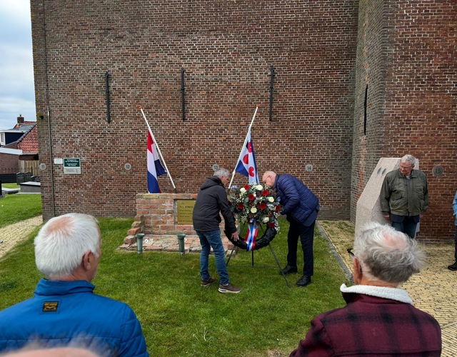 Kranslegging bij het monument naast de kerk in Hallum tijdens de herdenking van oorlogsslachtoffers.