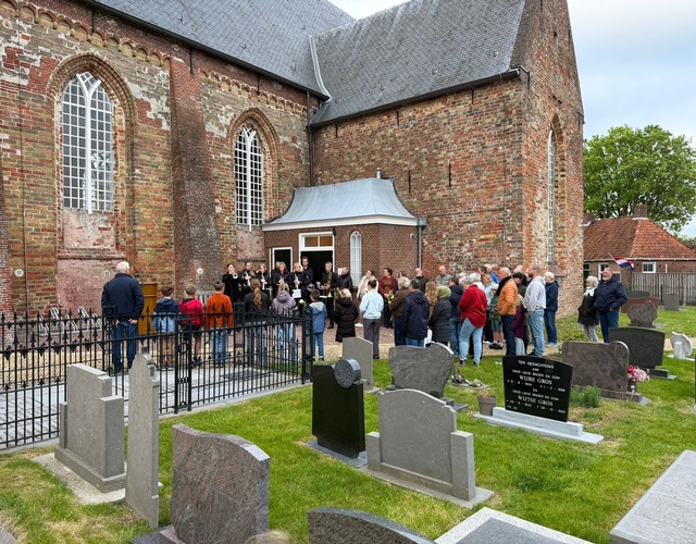 Muzikanten en bezoekers verzamelen zich bij de kerk in Hallum voor de herdenkingsbijeenkomst op 4 mei 2026.