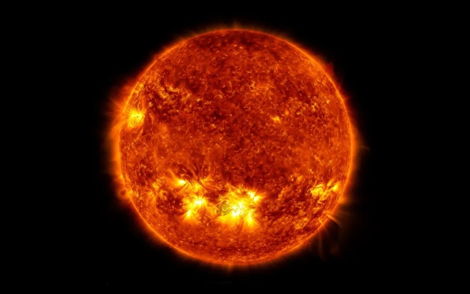 Close-up van de zon met felle uitbarstingen en gloeiende oppervlaktedetails tegen een zwarte achtergrond.