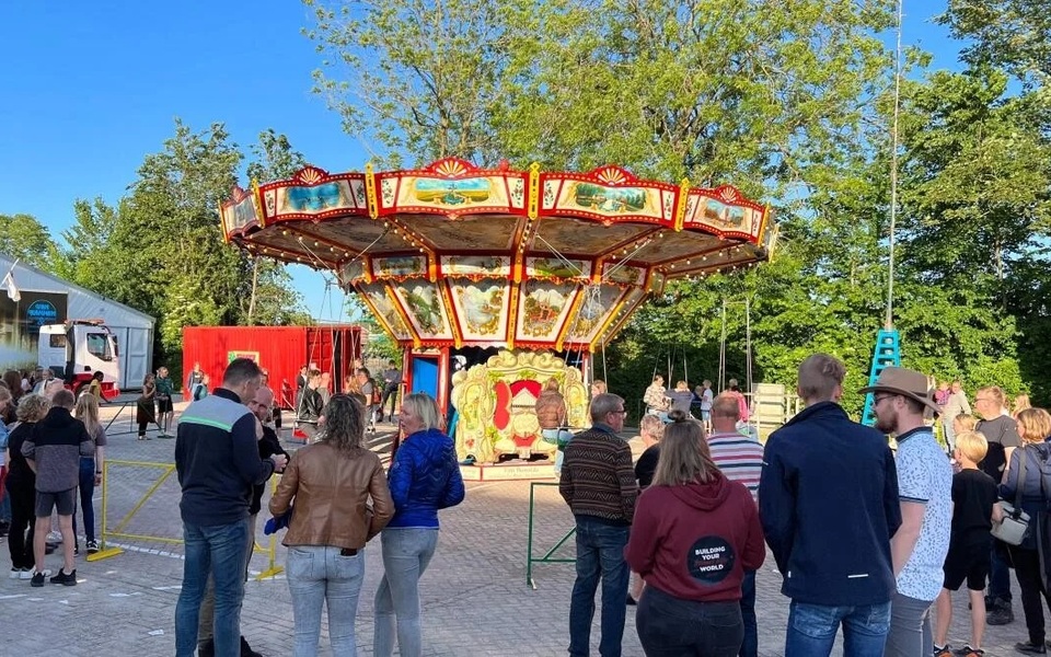 Bezoekers verzamelen zich rond een nostalgische draaimolen op het feestterrein tijdens het Hallumer dorpsfeest en de kermis.