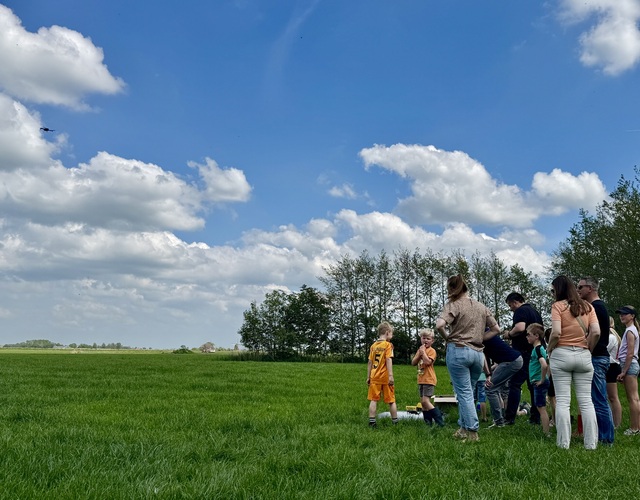 Kinderen en volwassenen kijken naar vogels en natuur in het open Friese landschap tijdens de Jeugdfûgelwachtdei 2026.