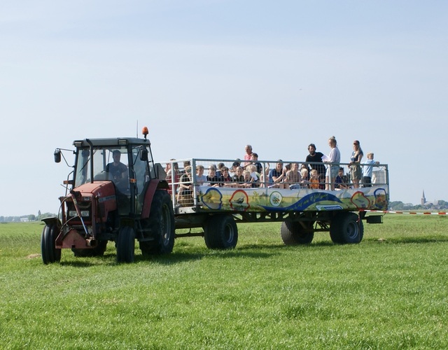 Platte wagentocht met kinderen en volwassenen door het Friese landschap tijdens de Jeugdfûgelwachtdei 2026.