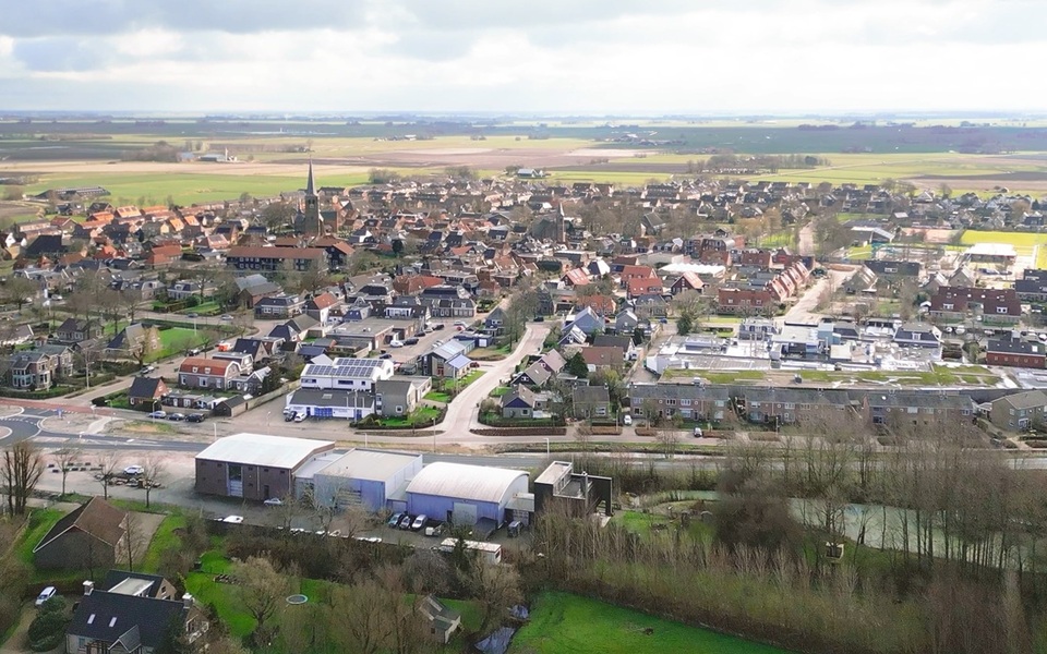 Een luchtfoto van Hallum in oostelijke richting met zicht op het oude station, de N357 en het dorp met de Sint Maarten kerk.