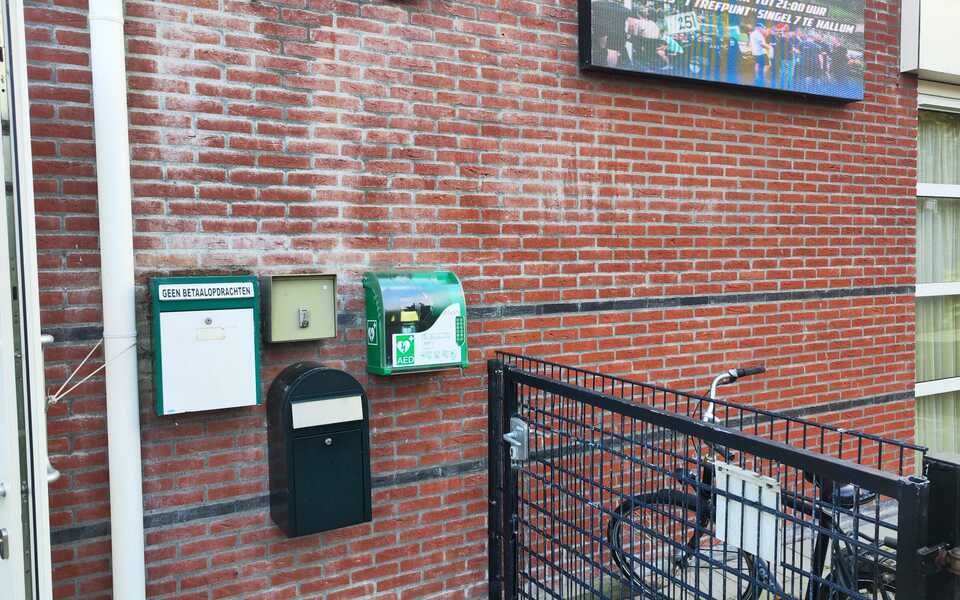 Nieuwe groene AED-buitenkast aan de gevel van MFC ’t Trefpunt aan De Singel in Hallum.