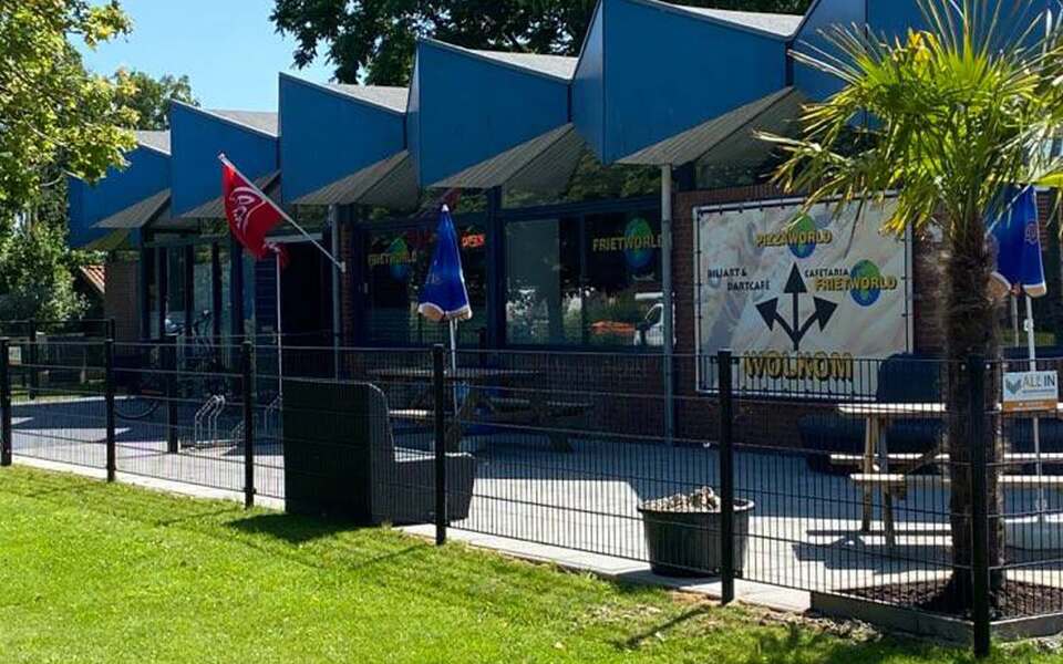 Buitenzijde van Frietworld en Pizza World aan De Singel in Hallum met terras.