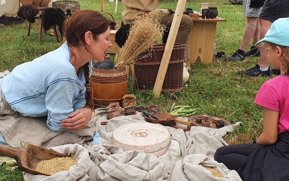 Reenactor van Monetarii Dorestatii vertelt een kind over vroegmiddeleeuwse ambachten en het dagelijks leven.
