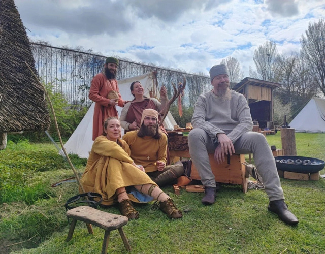 Leden van reenactmentgroep Monetarii Dorestatii in vroegmiddeleeuwse kleding bij hun kampement.